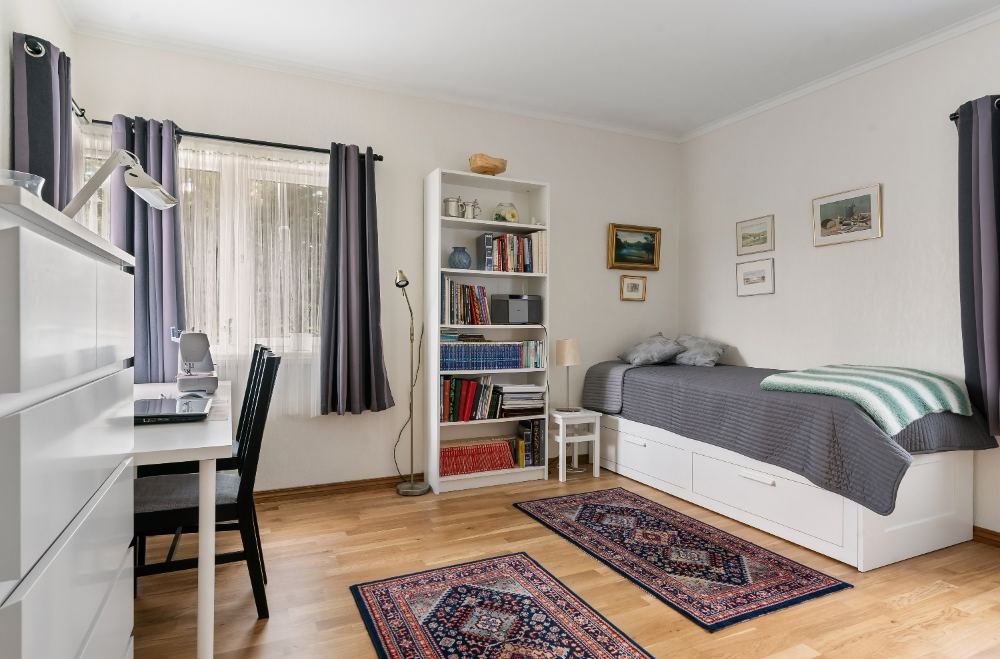 Tidy bedroom with made bed and dust-free surfaces